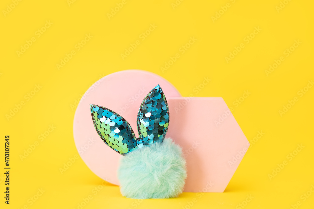 Easter blue fur bunny and pink podiums on yellow background. Minimal Easter concept
