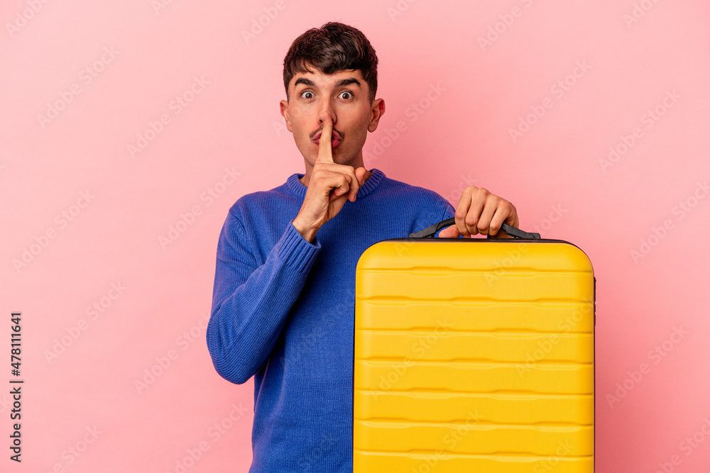 Young mixed race man going to travel isolated on pink background keeping a secret or asking for silence. Young mixed race man going to travel isolated on pink background keeping a secret or asking for silence.