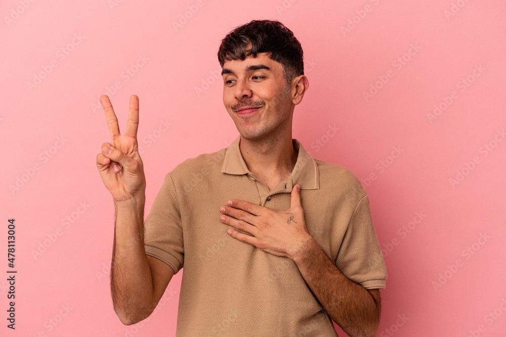 Young mixed race man isolated on pink background taking an oath, putting hand on chest. Young mixed race man isolated on pink background taking an oath, putting hand on chest.