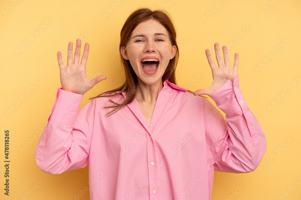 Young English woman isolated on yellow background receiving a pleasant surprise, excited and raising hands. Young English woman isolated on yellow background receiving a pleasant surprise, excited and raising hands.