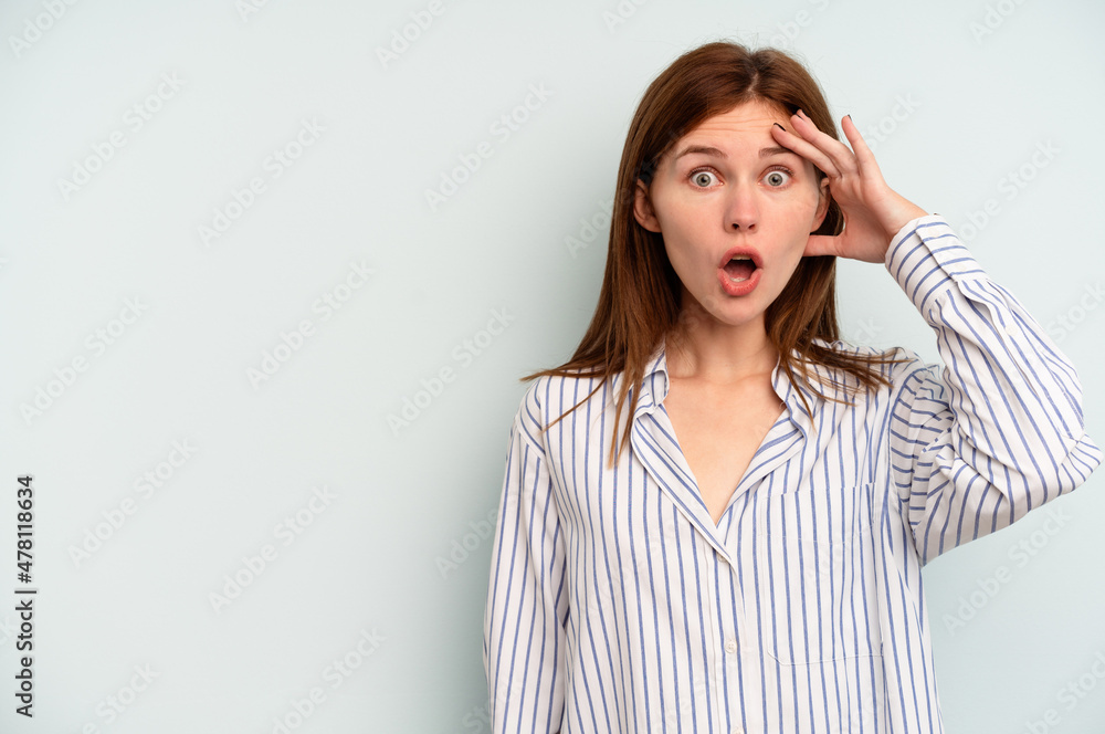 Young English woman isolated on blue background shouts loud, keeps eyes opened and hands tense. Young English woman isolated on blue background shouts loud, keeps eyes opened and hands tense.