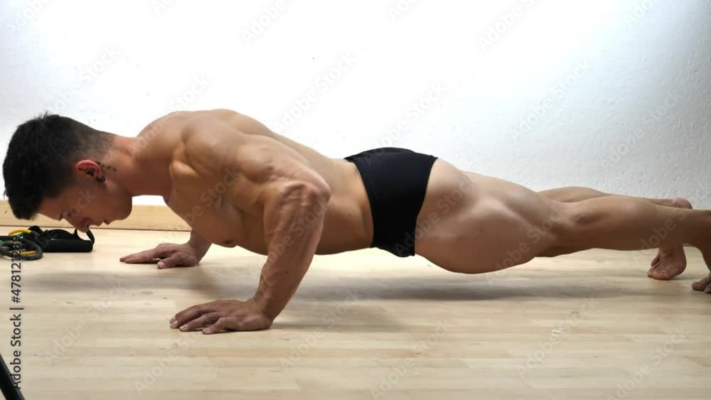 Young man in gym doing push-ups on the floor Young man in gym doing push-ups on the floor