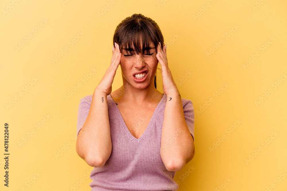Young Argentinian woman isolated on yellow background touching temples and having headache. Young Argentinian woman isolated on yellow background touching temples and having headache.