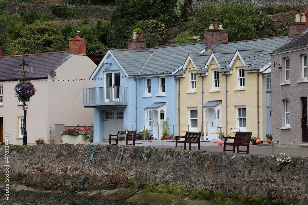 Lower Fishguard Harbour View with Traditional Colorful Cottages and Wooden Benches in Pembrokeshire, South Wales, UK