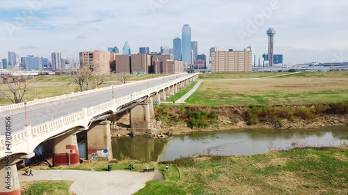 Aerial view local residents enjoy walking dogs and play outdoor along Trinity River near Downtown Dallas and Commerce Street