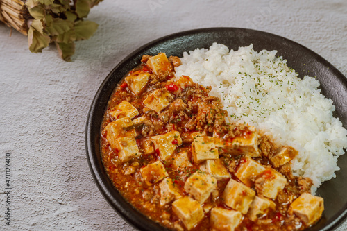 Chinese food mapo tofu dish and rice on black plate