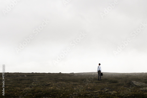 Back view of young businessman while standing with mist background © Sergey Nivens