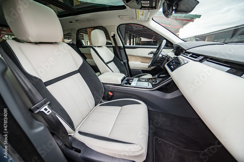 Modern luxury prestige car interior, dashboard, steering wheel. Orange red car interior. © Iryna