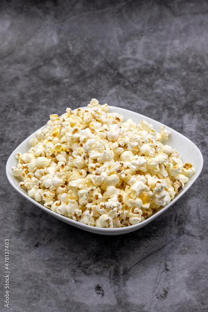 Popcorn on a dark background. Fresh popcorn in ceramic bowl. Close-up. Vertical view Popcorn on a dark background. Fresh popcorn in ceramic bowl. Close-up. Vertical view
