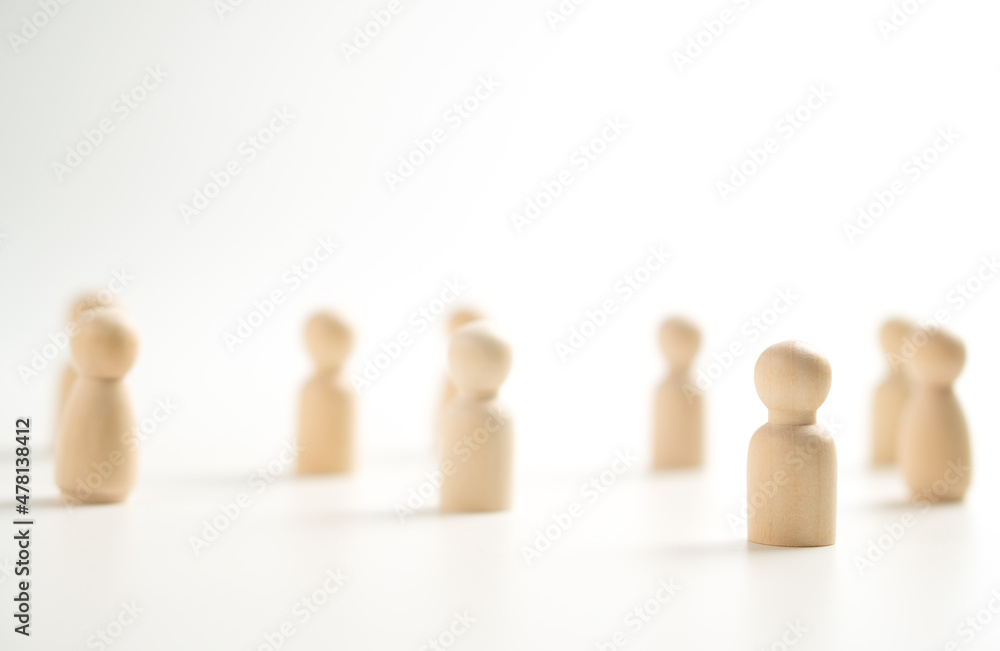 A wooden figure standing with a team to influence and empowerment. Concept of leadership, successful competition winner and Leader with influence and Social distancing for a new normal lifestyle A wooden figure standing with a team to influence and empowerment. Concept of leadership, successful competition winner and Leader with influence and Social distancing for a new normal lifestyle
