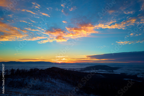 Sunset over mountans covered with forest, beautiful winter landscape, nature background, aerial view © Lazy_Bear
