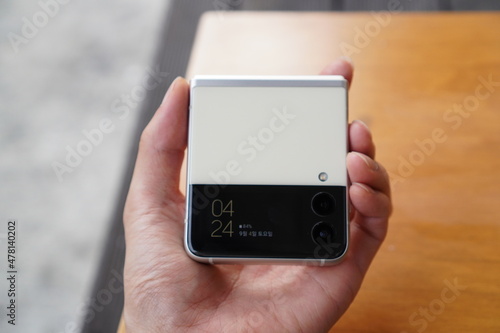 Hand holding a Samsung Galaxy Z Flip. A foldable smartphone made in south Korea.