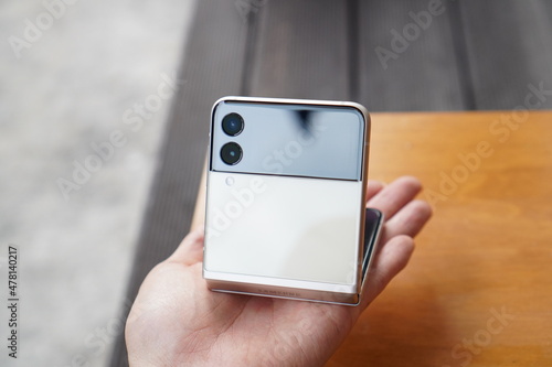 hand holding smartphone. Galaxy Z Flip, a foldable smartphone from Korea.
