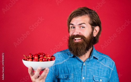 brutal bearded male man hold cherry berry, organic