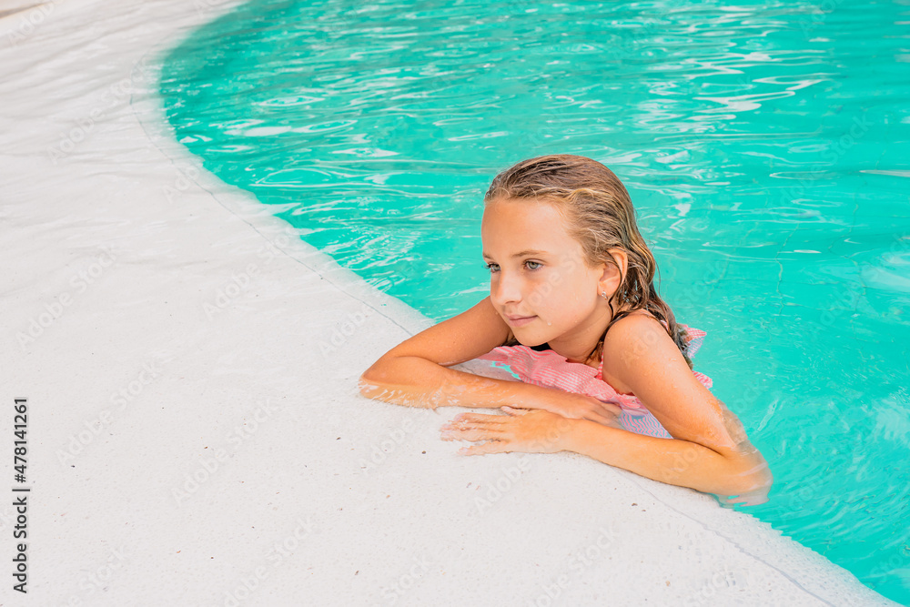 Beautiful little girl posing in the pool. Hight quality photo