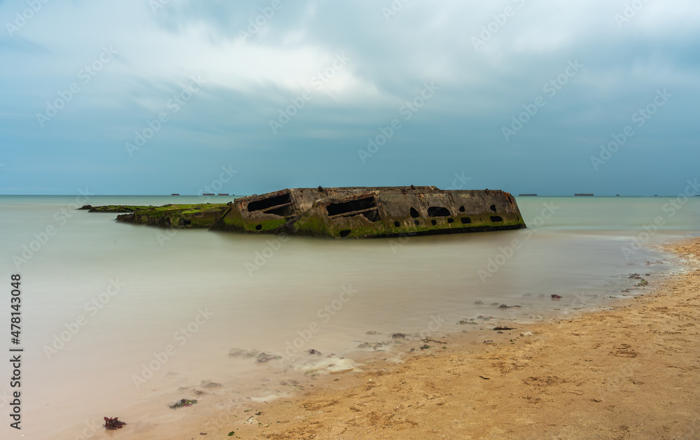 Arromanches, France - August 2, 2021: Remains of artificial military landing port in Arromanches  in Normandy - long exposure