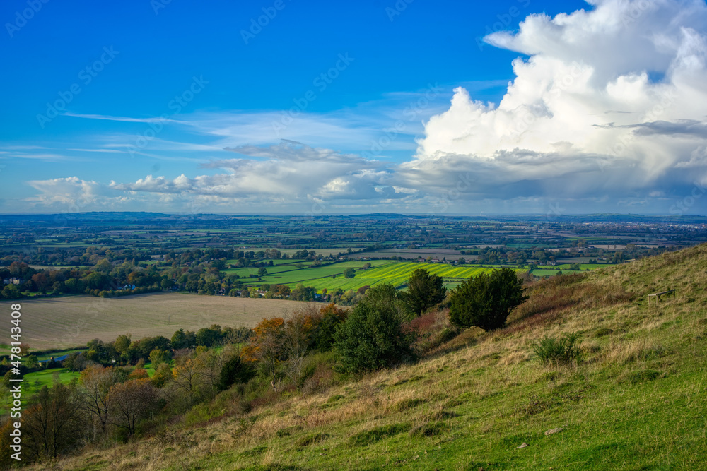 Naklejka premium Valley and blue skies seen from high up a hill