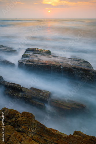 waves and rocks in sunset in long exposure