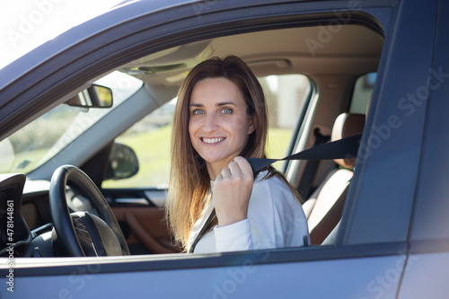 Beautiful caucasian lady fastening car seat belt.  © Julija