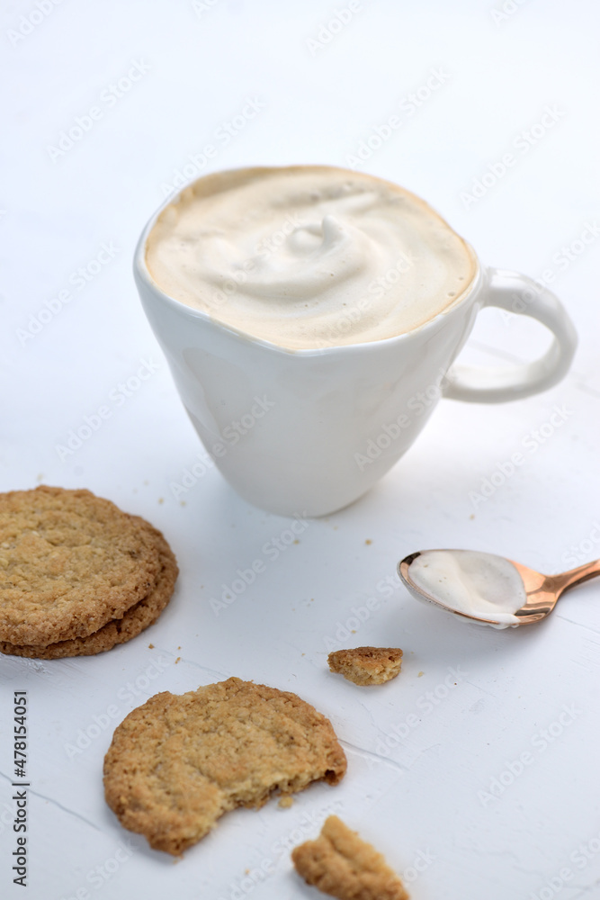 Latte or Cappuccino with frothy foam, coffee cup over rustic background Latte or Cappuccino with frothy foam, coffee cup over rustic background