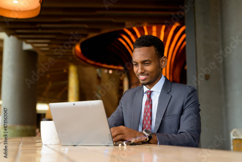 Photography Portrait of African businessman wearing suit and tie in coffee shop