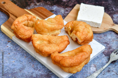 Traditional Bulgarian home made deep fried  patties  covered with sugar  оn rustic backgroud.Mekitsa or Mekica,  on wooden  rustic  background. Made of kneaded dough that is deep fried  photo