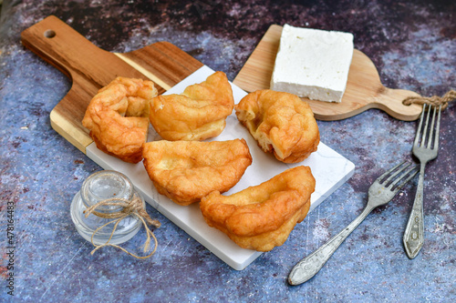 Traditional Bulgarian home made deep fried  patties  covered with sugar  оn rustic backgroud.Mekitsa or Mekica,  on wooden  rustic  background. Made of kneaded dough that is deep fried  photo