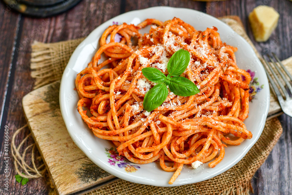 Spaghetti bolognese .Italian home made meal Fresh bucatini pasta with tomato sauce, basil, herbs ,parmesan cheese ,fresh cherry tomatoes and parsley on wooden background. Kitchen Poster Spaghetti bolognese .Italian home made meal Fresh bucatini pasta with tomato sauce, basil, herbs ,parmesan cheese ,fresh cherry tomatoes and parsley on wooden background. Kitchen Poster