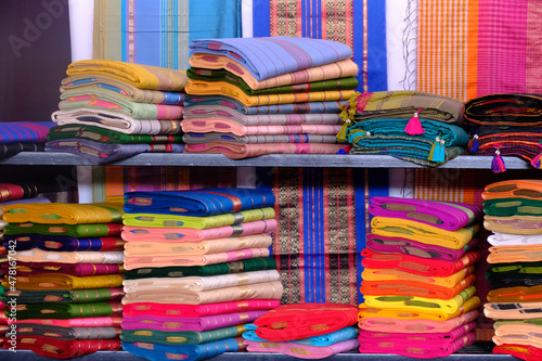Fotografija Artistic variety shade tone colors ornaments patterns, closeup view of stacked saris or sarees in display of retail shop