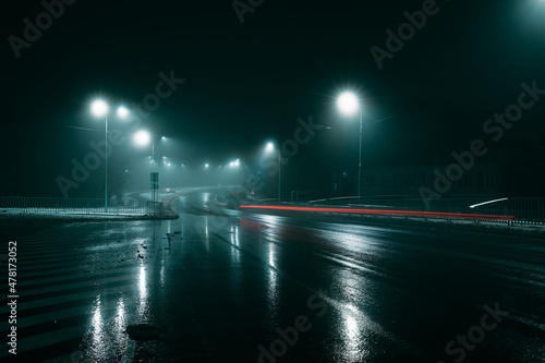 Lights of the car on the street of the city at night in the fog