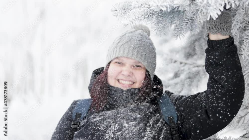 Young beautiful girl walking in the snowy winter forest. She is happy and calm. A girl stands near a large snow-covered spruce and carefully examines it. Slow motion. Full HD. Young beautiful girl walking in the snowy winter forest. She is happy and calm. A girl stands near a large snow-covered spruce and carefully examines it. Slow motion. Full HD.