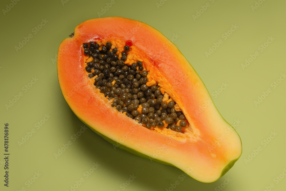 Papaya fruit on a green background. Half papaya. Papaya fruit on a green background. Half papaya.