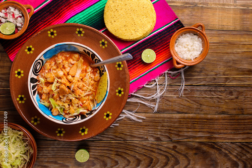 red pozole, with pork and vegetables, radish, onion, lettuce, served with toasted tortillas photo