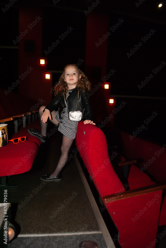 a cute little girl stands in a charismatic pose looking at the camera with her eyes a cute little girl stands in a charismatic pose looking at the camera with her eyes