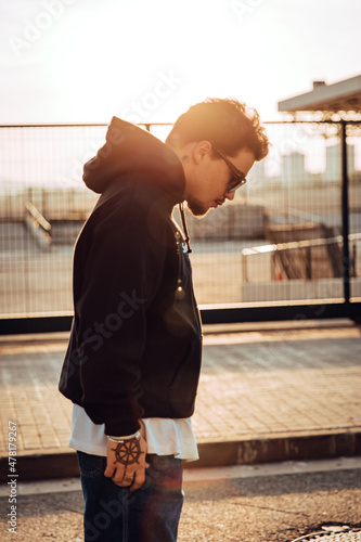 Urban portrait of a stylish tattooed guy during sunset photo