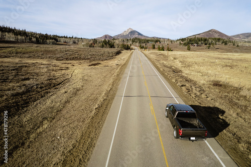 Pickup truck drives straight road toward's Hahn's Peak, Colorado photo