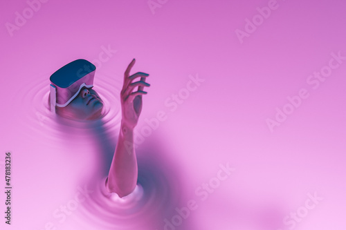 surreal girl with VR glasses immersed in liquid photo