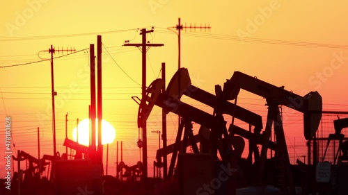 The sun rises behind oil pumps in California