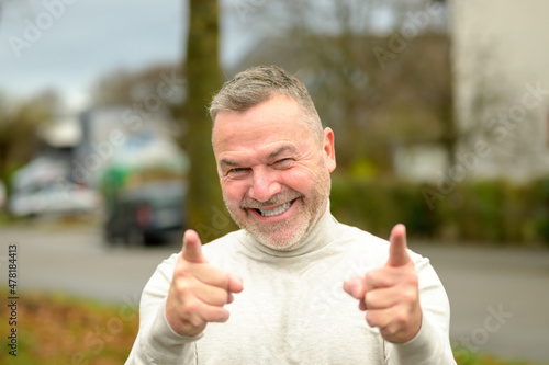Gleeful elated man grinning broadly at the camera