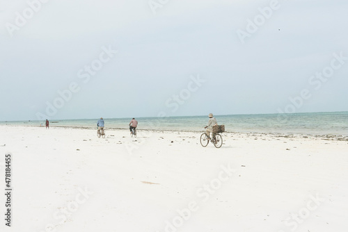 Three men on bikes in Zanzibar, Tanzania, Africa 