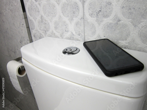     close up of toilet paper and a smart phone to work from the toilet   