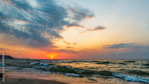 Sunset in the wavy sea in a beautiful multicolored sky