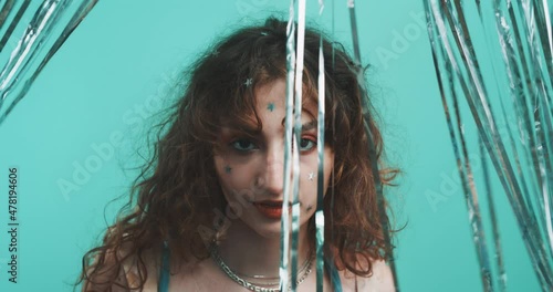 Curly girl dancing through a glitter curtain. photo