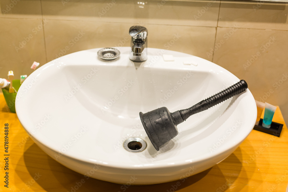 Household Black Sink Plunger Tool In Bathroom Sink Plugged With Pink 