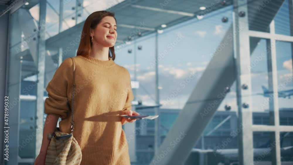Airport Terminal: Beautiful Smiling Woman Holds Ticket, Walks Through Big Airline Hub to the Gates Where Her Airplane Waits Her. Happy Caucasian Female is Ready for Her Flight to Vacation Destination