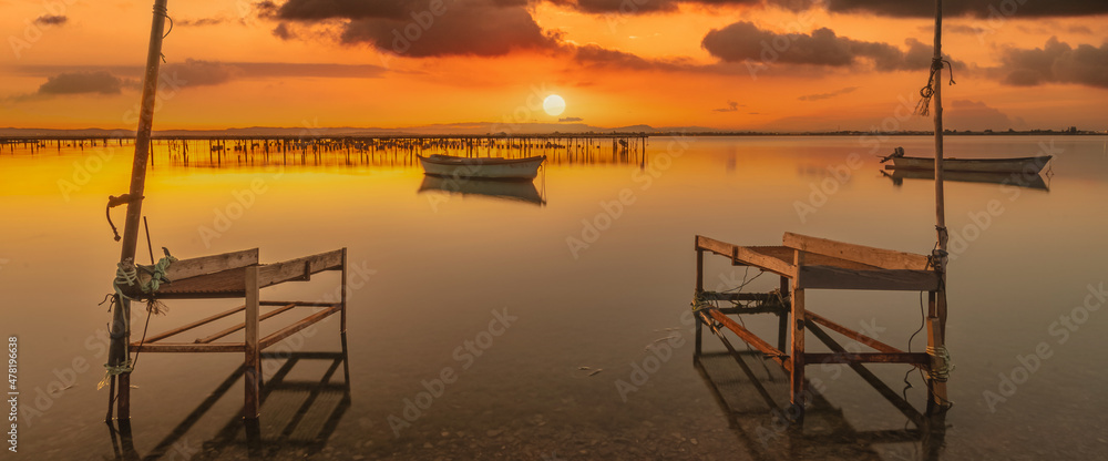 	
Vue d'un coucher de soleil sur les parcs à moules d'un étang de la Camargue, réserve naturelle protégée