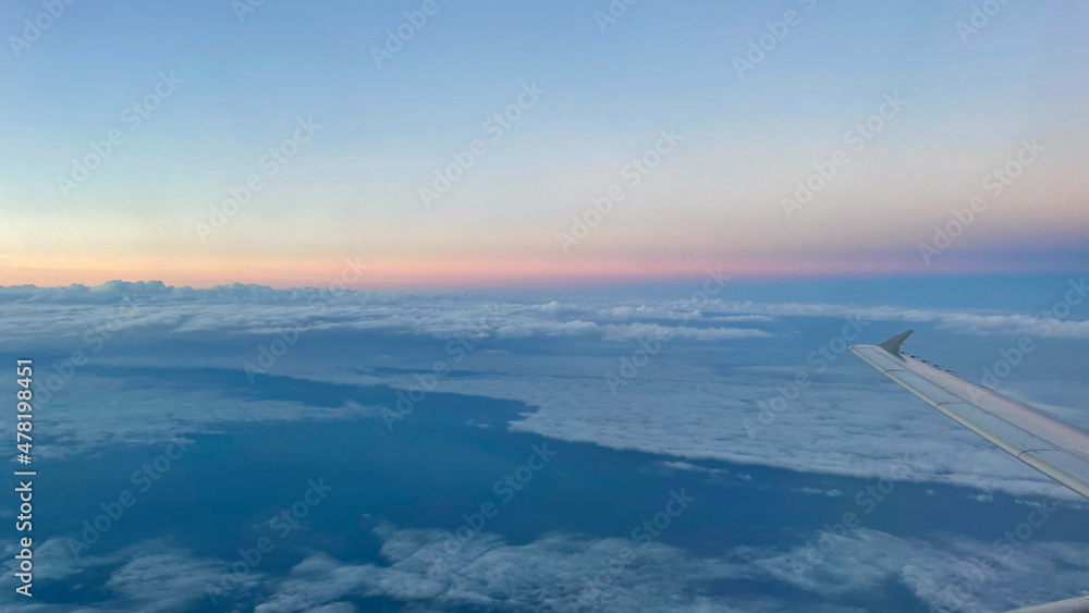 View from airplane above clouds and city