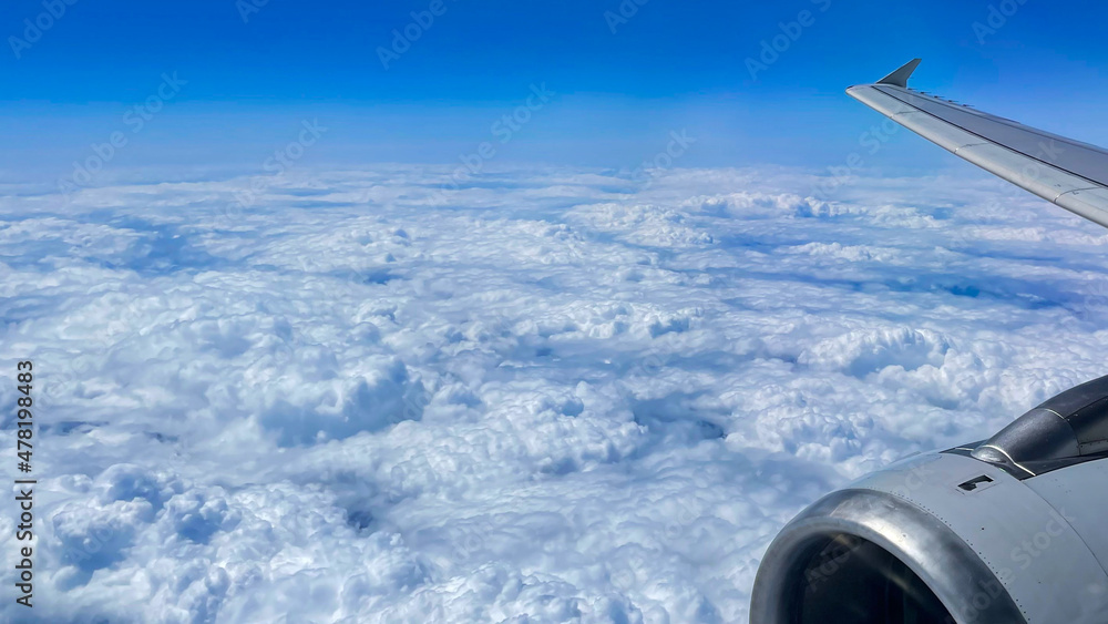 Fototapeta premium View from airplane above clouds and city
