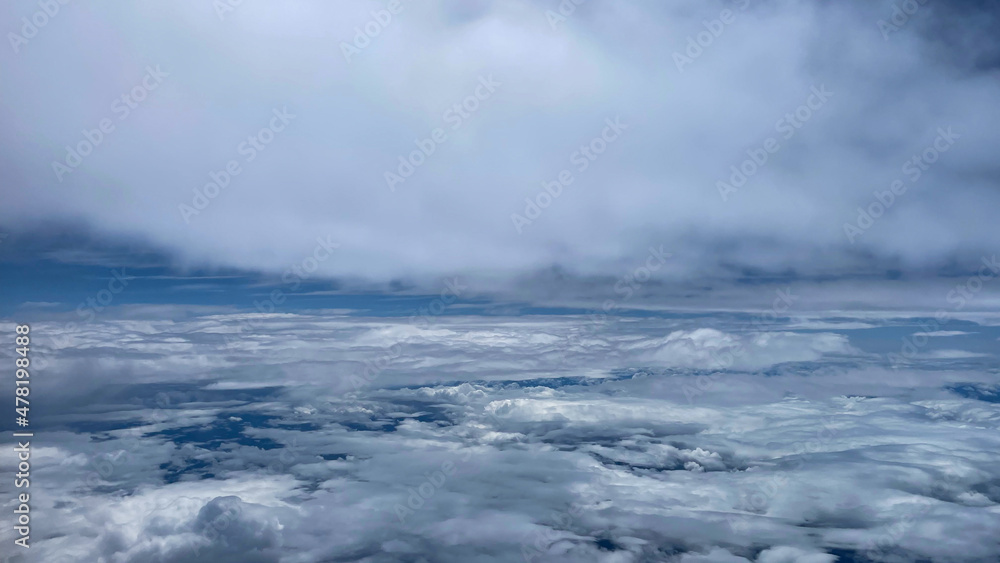 View from airplane above clouds and city