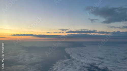 View from airplane above clouds and city